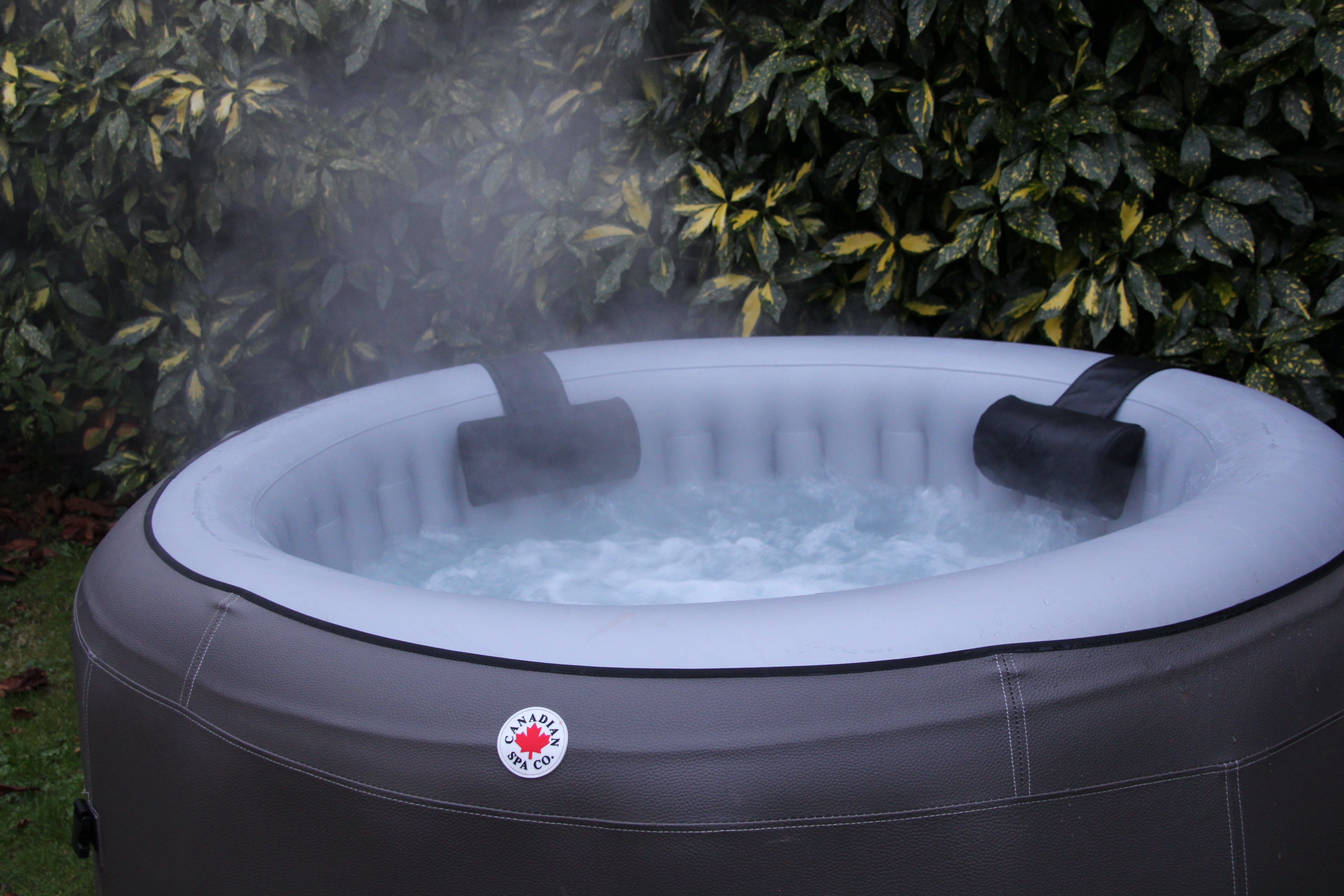 Inflatable Canadian Spa Grand Rapids hot tub in the garden with massage active and rising steam