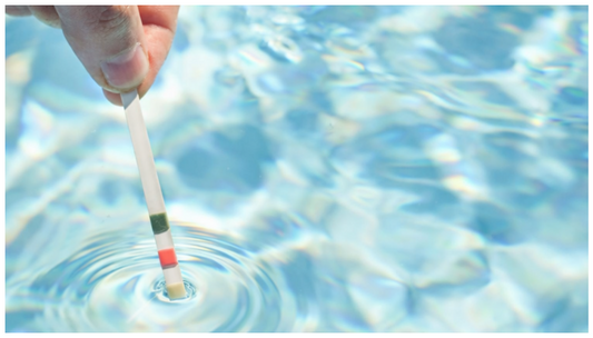 Nahaufnahme einer Hand, die einen 3-in-1 Whirlpool-Teststreifen in klares, blaues Wasser eintaucht, während sich leichte Wasserwellen um den Streifen bilden.